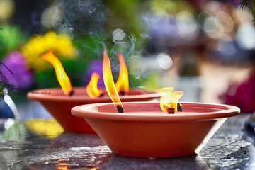 Ogień na symbolicznym zniczu na grobie ku pamięci. © FotoDax