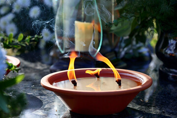 Ogień na symbolicznym zniczu na grobie ku pamięci. © FotoDax