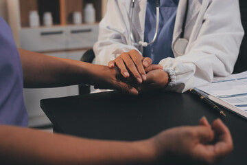 Kind male doctor wearing white coat consulting elder senior female patient holding hand of older...