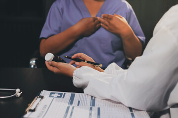 Senior woman holding medicine bottle with nurse using laptop at home