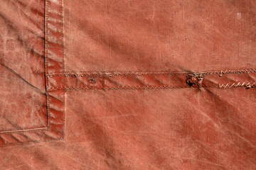 Closeup of old red canvas sail as used on Thames Barges for use as a background texture