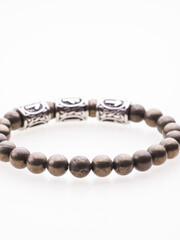 A charming double bracelet in shades of pink, made from natural stone and set against a gray background. The heart charm with cubic zirconia stands out in this close-up top view