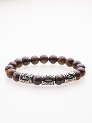 A charming double bracelet in shades of pink, made from natural stone and set against a gray background. The heart charm with cubic zirconia stands out in this close-up top view