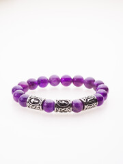 A charming double bracelet in shades of pink, made from natural stone and set against a gray background. The heart charm with cubic zirconia stands out in this close-up top view