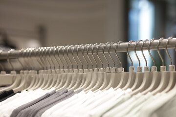 Clothes hangers with sizes displayed in rows on the clothes rack. Clothes hangers are arranged neatly.