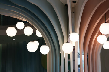 The building is decorated with round lamps. Decorate the building pillars in a modern style with round lamps.