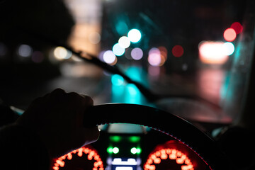 雨の夜に自動車を運転する男性の手元