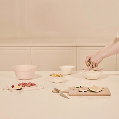 Minimalist Kitchen Setting with Pink Bowls and Wooden Cutting Board