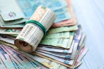 Big amount of different ukrainian hryvnia currency money bills on wooden background