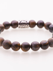 A charming double bracelet in shades of pink, made from natural stone and set against a gray background. The heart charm with cubic zirconia stands out in this close-up top view