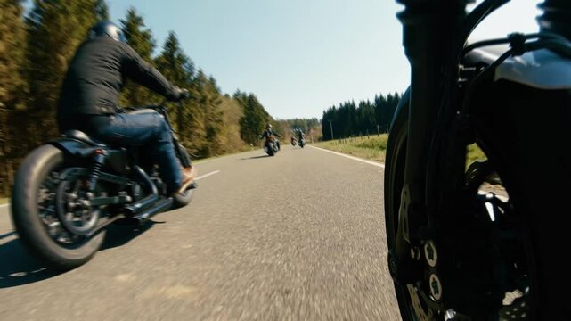 motorbike on the forest road riding. Friends having fun driving the empty road on a motorcycle tour journey.