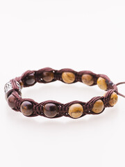 A charming double bracelet in shades of pink, made from natural stone and set against a gray background. The heart charm with cubic zirconia stands out in this close-up top view