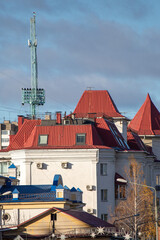 A red building with a blue roof and a white building in the background