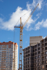 A crane is lifting a large object in front of a building