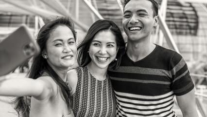 Three young asian friends spending outdoor time together in the city