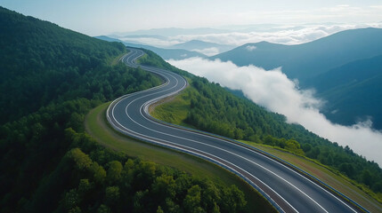 winding highway through lush green mountains, surrounded by clouds and mist, creates serene and picturesque landscape. road curves gracefully, inviting exploration