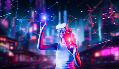 Fototapeta premium Female stand in cyberpunk style building in VRX wear VR headset connect metaverse, future cyberspace community technology. Woman use fingers touch objects, light appear where she stab. Hallucination.