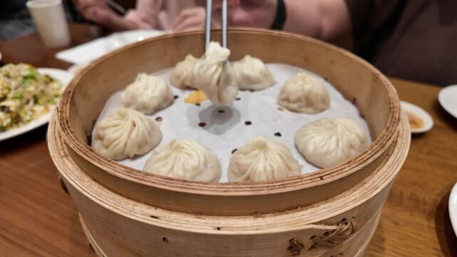 Motion of woman eating soup dumpling buns with chopsticks in restaurant in Taipei Taiwan with 4k resolution.