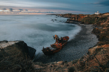 A shipwreck in portgular at sunset with a long exposure