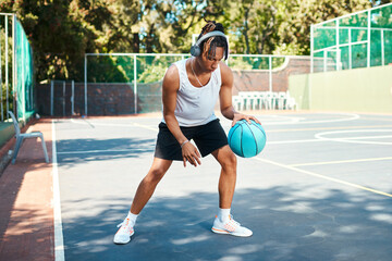 Obraz premium Man, sports and ball on basketball player on court as athlete for challenge, cardio and training. Male person, headphones and outdoor for competition, match and game in physical activity or exercise