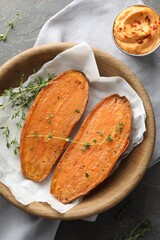 Tasty cooked sweet potato with thyme and sauce on grey table, top view