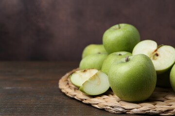 Whole and cut green apples on wooden table. Space for text