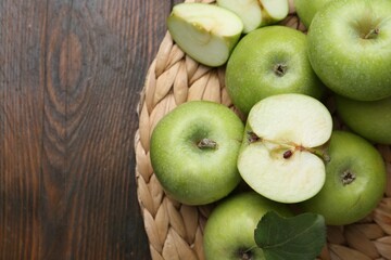 Whole and cut green apples on wooden table, top view