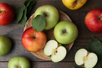 Different ripe apples on wooden table, flat lay