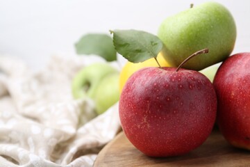 Different whole ripe apples on wooden table, closeup. Space for text