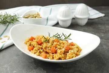Delicious pumpkin risotto on grey table, closeup