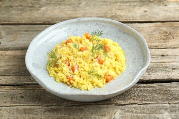 Delicious pumpkin risotto on wooden table, closeup