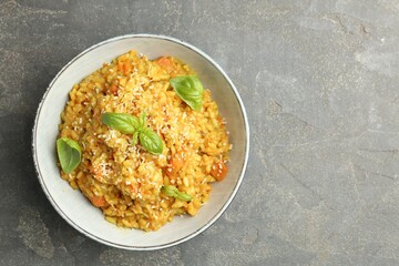 Delicious pumpkin risotto on grey table, top view. Space for text