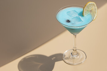 Bright Blue Margarita in Elegant Martini Glassware. Perfect for summer bar promotions, accentuating the drink’s color and appeal.