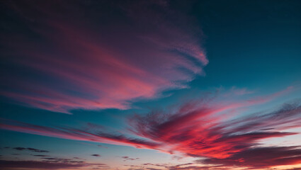 Fototapeta premium Richly colored red and pink clouds in a deep blue evening sky.
