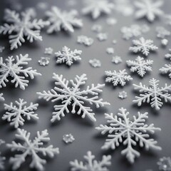 The photo shows a minimalist winter background: snowflakes along the edges form a frame on a light gray background. Small snow dots are scattered across the surface, creating a calm and chilly winter 