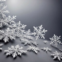 The photo shows a minimalist winter background: snowflakes along the edges form a frame on a light gray background. Small snow dots are scattered across the surface, creating a calm and chilly winter 