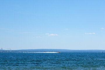 Obraz premium Speed boat runs over wide river