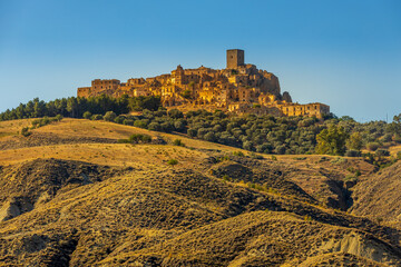 A picturesque view of the abandoned, old mountain town of Craco, built of sandstone rock. Craco is a ghost town abandoned due to an earthquake in the late 20th century. Province of Matera, Basilicata,