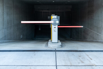 Fototapeta premium Automatic barriers at the entrance to the parking area. Underground parking entrance. Modern concrete building.
