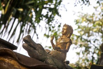 goddess dharani mata on crocodile, old golden statue, temple in thailand