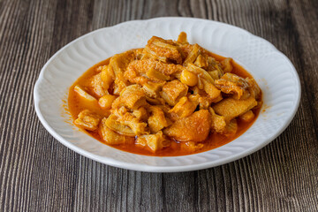 A dish from Turkish cuisine. Lamb tripe with chickpeas served on a white plate.