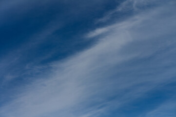 Vast blue sky with wispy clouds drifting above a serene landscape during a tranquil afternoon