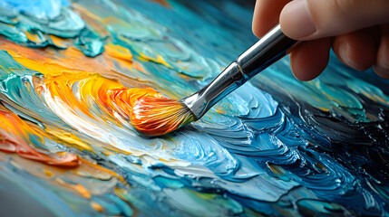 Fototapeta premium Artistic Hand Painting with Vibrant Oil Colors on Canvas, Close-Up of Brushstrokes Blending Blue, Orange, and Yellow Hues, Capturing the Creative Process of Abstract Expressionism in Modern Art
