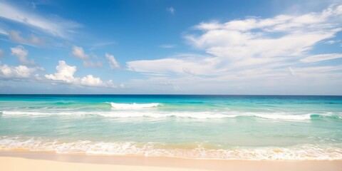 Fototapeta premium Sandy beach with gentle waves and clear blue sky, sunny, ocean