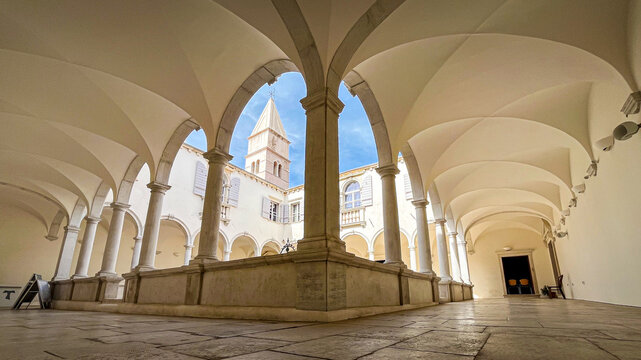 Clo�tre au grand angle avec vue sur le clocher sous les arches
