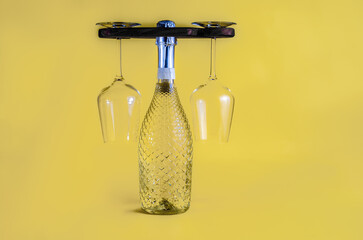 Wine bottle and pair of glasses caddy holder yoke style isolated on a yellow background