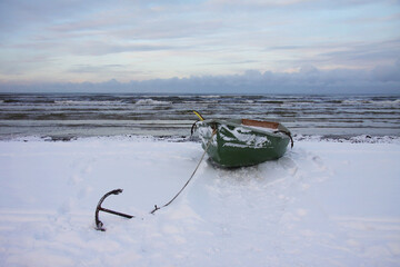 Winter landscape from the seashore,.  Fisherman boat on the seashore,  ice texture in Winter. 