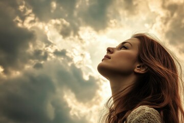 A woman gazes up at the cloudy sky with a thoughtful expression