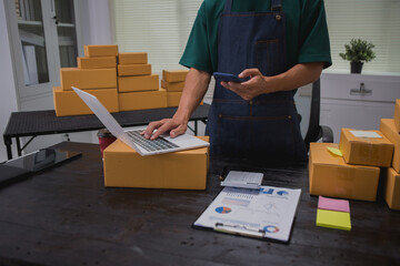 An Asian man carefully prepares a package for a customer's online order, methodically placing items in a box, sealing it securely, and attaching a shipping label for prompt delivery.