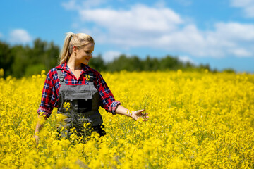 Fototapeta premium A Young Woman is Joyfully Enjoying the Amazing Beauty of a Vibrant Yellow Flower Field